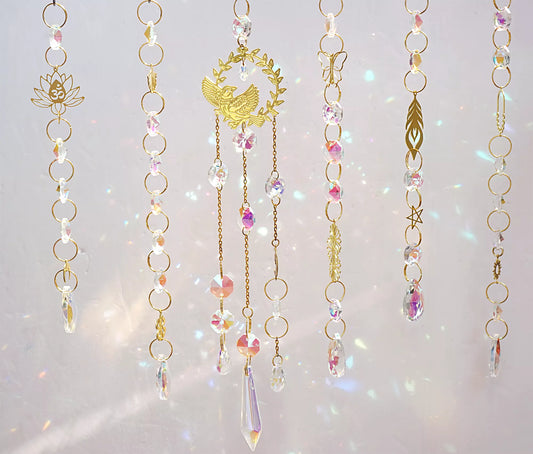 handmade suncatchers featuring delicate brass charms in the shape of birds, butterflies, lotus flowers, and ginkgo leaves
